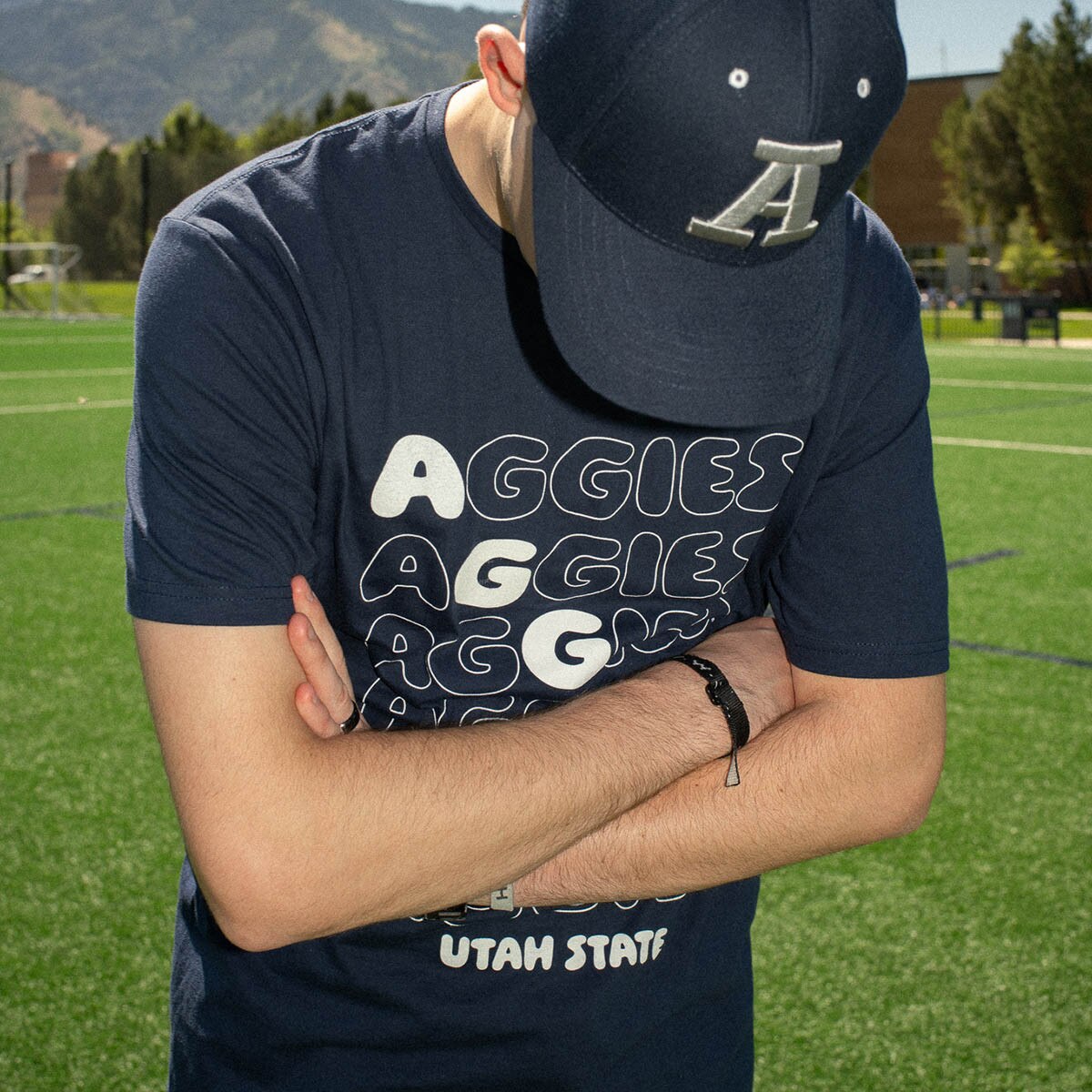 Young man wearing gameday t-shirt and Block A hat on soccer field